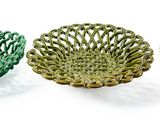 trois bols en verre de couleurs différentes posés les uns à côté des autres sur une surface blanche