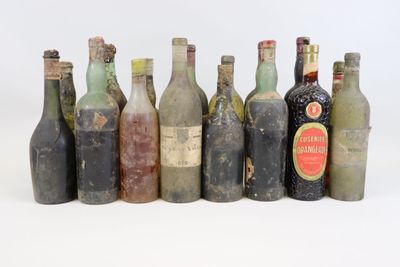 several old bottles of alcohol are lined up in a row