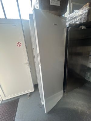 un réfrigérateur et un congélateur dans une pièce où se trouvent de nombreux cartons