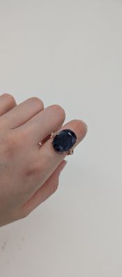 la main d'une femme tenant une bague sertie d'une pierre noire