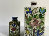 two small vases sitting next to each other on a table