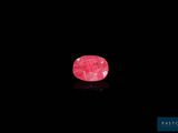un gros plan d'une pierre rose sur une surface noire