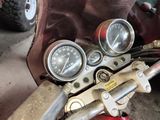 gauges on the handlebars of a motorcycle in a garage