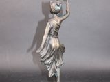 silver statue of a woman holding a vase on a marble base