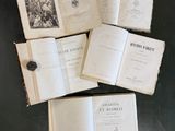 plusieurs livres ouverts posés sur une table, avec un bouton par-dessus