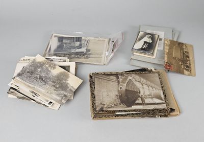 une vieille photo montrant deux personnes assises sur une table, à côté d'une pile de vieilles photos