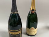 deux bouteilles de champagne et un verre de vin posés sur une table