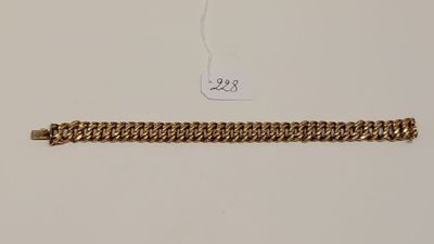 Gros plan sur un bracelet en chaîne en or portant une étiquette