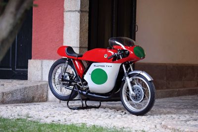 une moto rouge et verte garée devant un immeuble