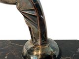 a silver sculpture of a man on a marble base