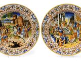 two plates with a painting of a biblical scene on them