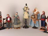 sept figurines représentant des personnes vêtues de costumes traditionnels