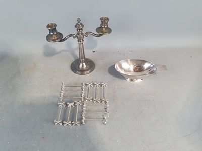 une assiette en argent et un bougeoir en argent posés sur une table