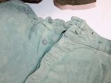 a pair of green pants and a pair of brown shoes