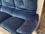a blue couch that is sitting in front of a fire place