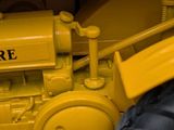 a yellow toy tractor that is sitting on a table