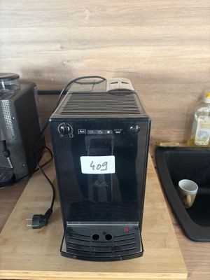 une machine à café noir posée sur un plan de travail à côté d'un évier