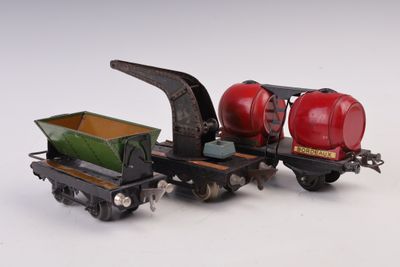 un petit train miniature sur lequel est posé un char rouge