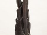 statue of a woman holding a piece of wood on top of a white pedestal