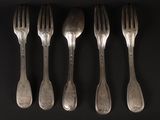 six forks and spoons are arranged in a row on a black surface