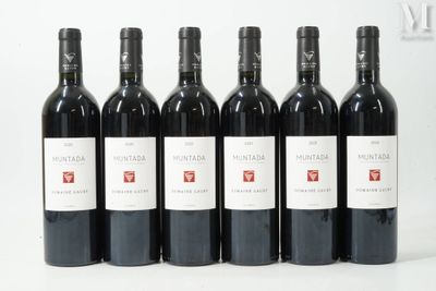 six bottles of wine are lined up in a row on a white surface