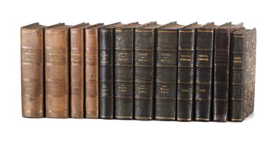 several old books are lined up in a row on a white surface