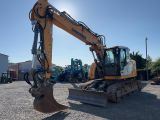 the back end of a yellow and black excavator parked in a parking lot