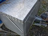 a metal box sitting on the ground next to a blue tarp