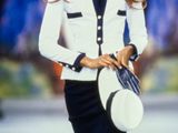 woman in white jacket and black skirt walking down runway