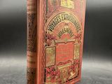 an old red book with gold lettering on it sitting on a table