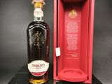une bouteille de whisky posée sur une boîte noire