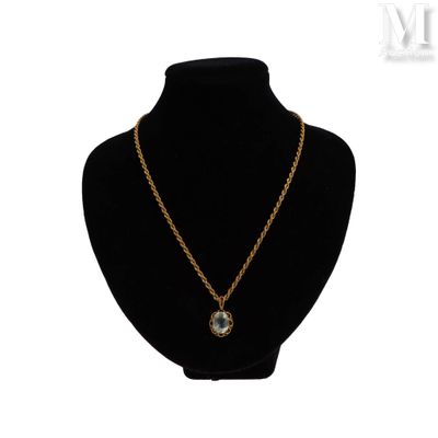 un collier composé d'une chaîne en or et d'un pendentif en pierre bleue