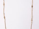 a gold necklace with a long chain with beads on it
