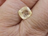 a close up of a person ' s hand holding a yellow diamond