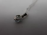 a close up of a necklace on a table with a white background