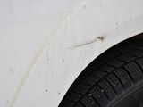 a close up of a tire on the side of a white car