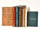 several old books are lined up on a white surface