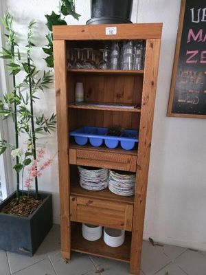 une grande armoire en bois sur laquelle sont posés de la vaisselle et des verres