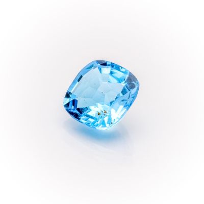 a close up of a blue topazte gems on a white surface