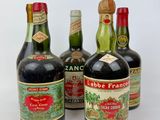 several bottles of wine are lined up on a white surface