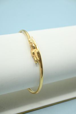 a close up of a gold bracelet on a white napkin