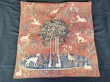 un coussin sur lequel sont représentés un arbre et des animaux
