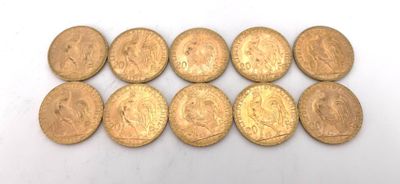 un groupe de pièces d'or posées sur une surface blanche