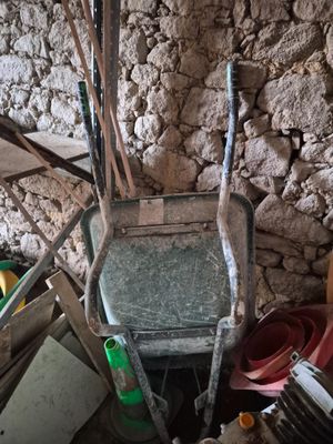 une brouette au milieu d'un tas de vieilleries