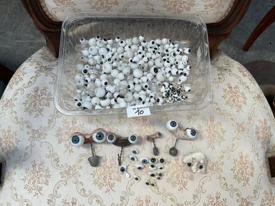 un récipient en plastique rempli de globes oculaires posé sur une chaise
