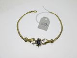 un bracelet en or orné d'une pierre bleue au centre