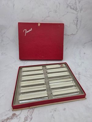 a red box filled with silver and white chocolates on top of a marble counter