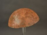 an old rusted helmet on a metal stand