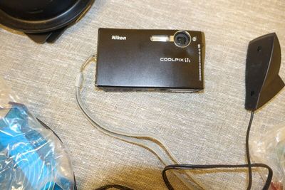 un appareil photo noir posé sur une table, à côté d'un casque audio