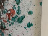a red and green paint splattered on a white wall